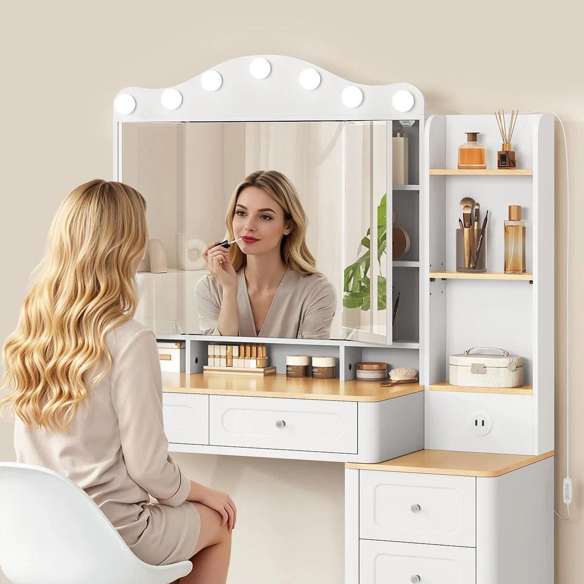 A woman doing her make-up in front of the lit tri-fold mirror