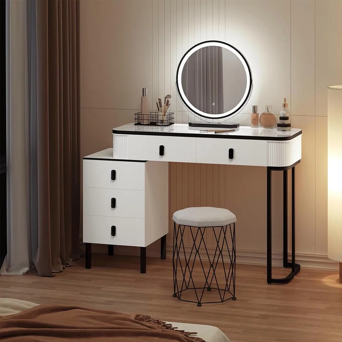 White and black dressing table with its round mirror lit up, its drawer unit and its velvet stool