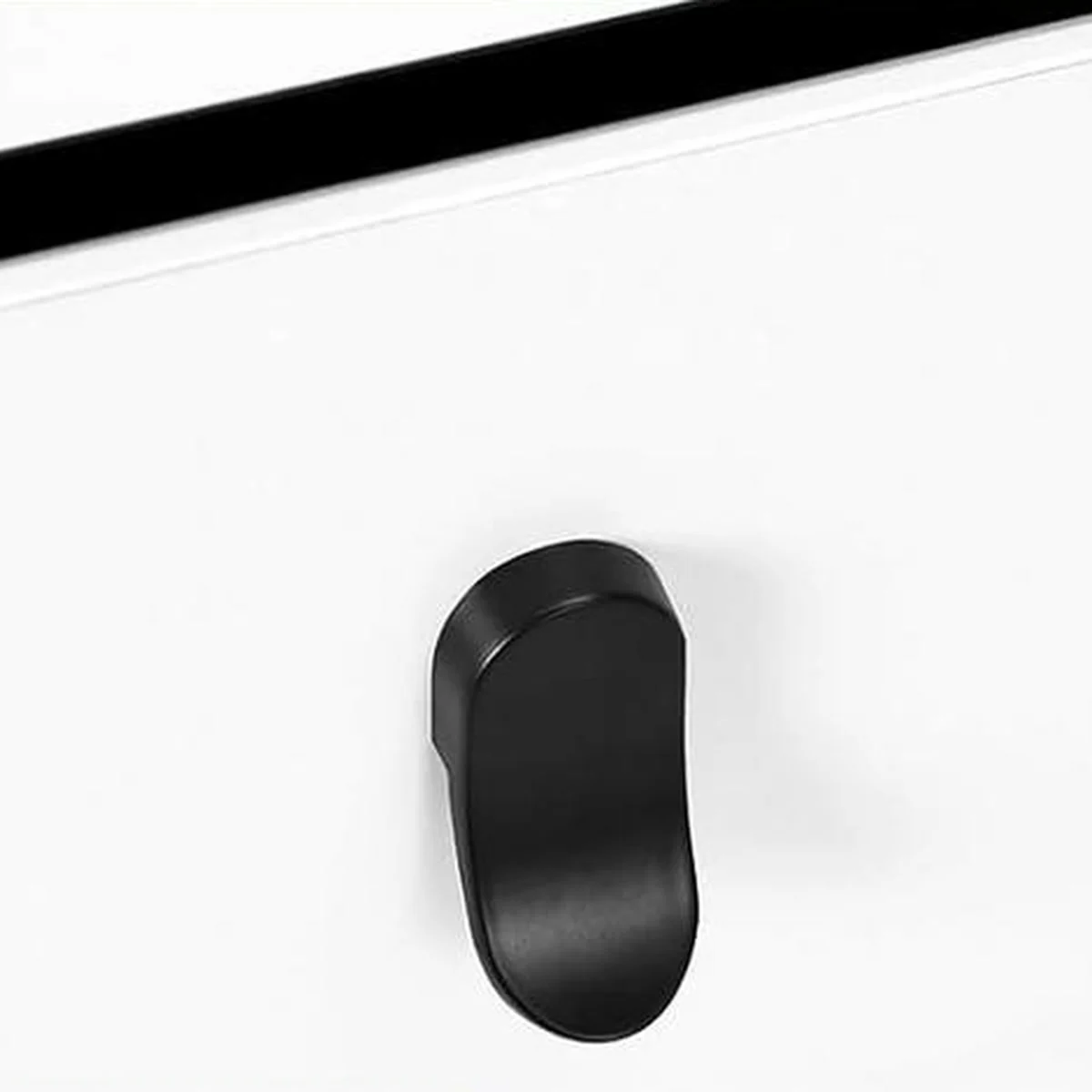 The black metal handle of a drawer