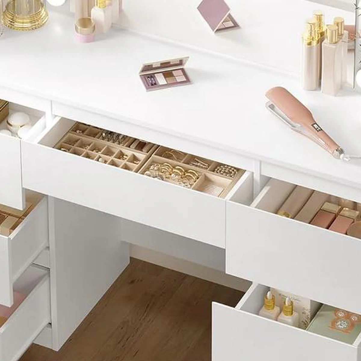 The drawers open, with jewellery, lipsticks and bottles neatly stored